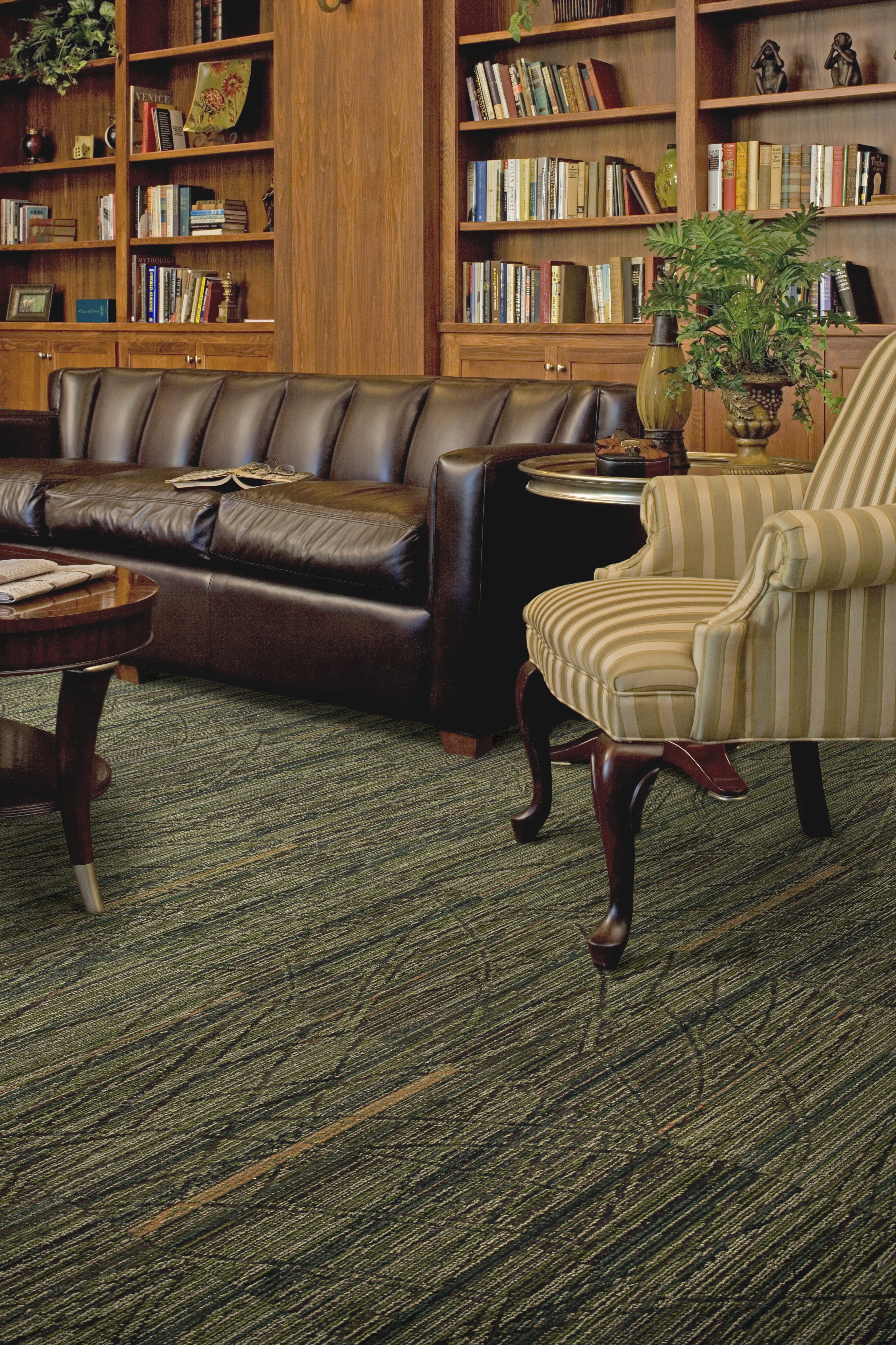 Interface Prairie Grass carpet tile in senior housing seating area with leather sofa and bookshelves